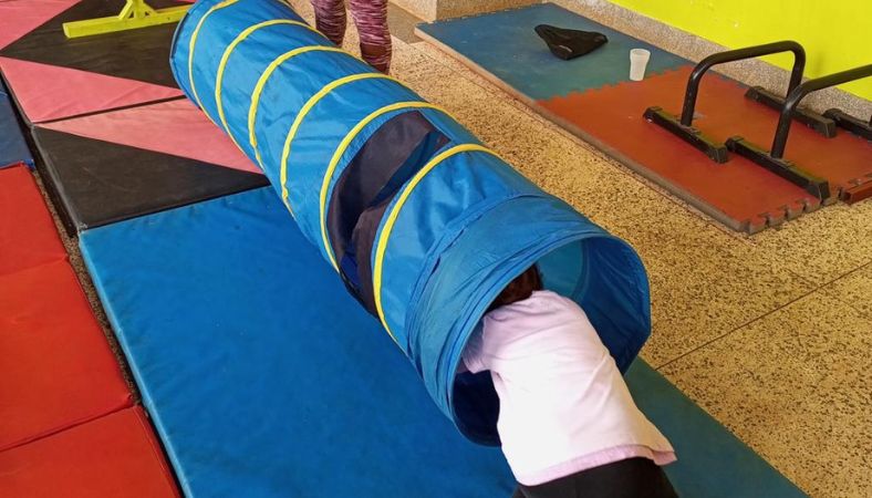 Boys gymnastics classes learning fun movements and climbing through gym apparatuses